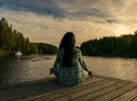  person meditating near a lake
